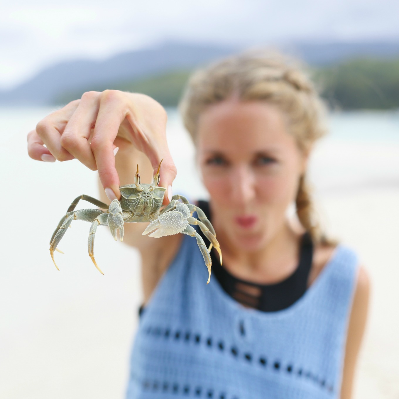 girl holding crab on beach
