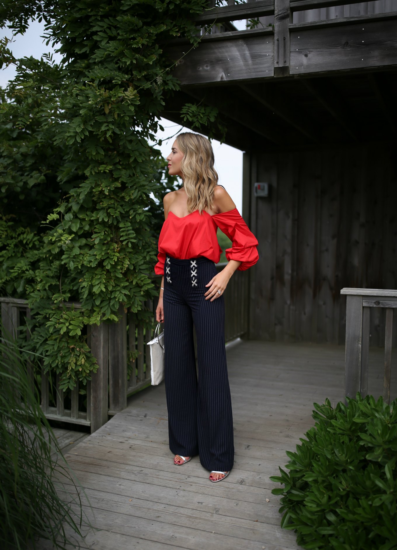 NYC fashion blogger Mary Orton in red Carolina Constas off the shoulder top and Veronica Beard x lace up pinstripe wide leg pants