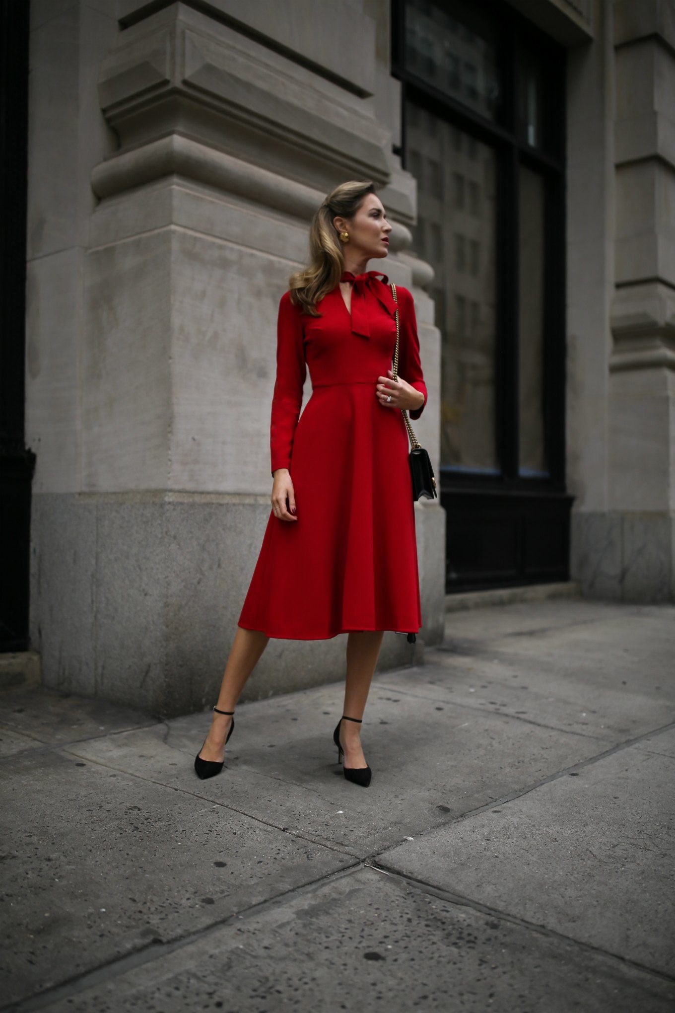 NYC fashion blogger Mary Orton of Memorandum wears a Black Halo tie-neck midi dress, black Sam Edelman ankle-strap pumps and a black leather Gucci bag