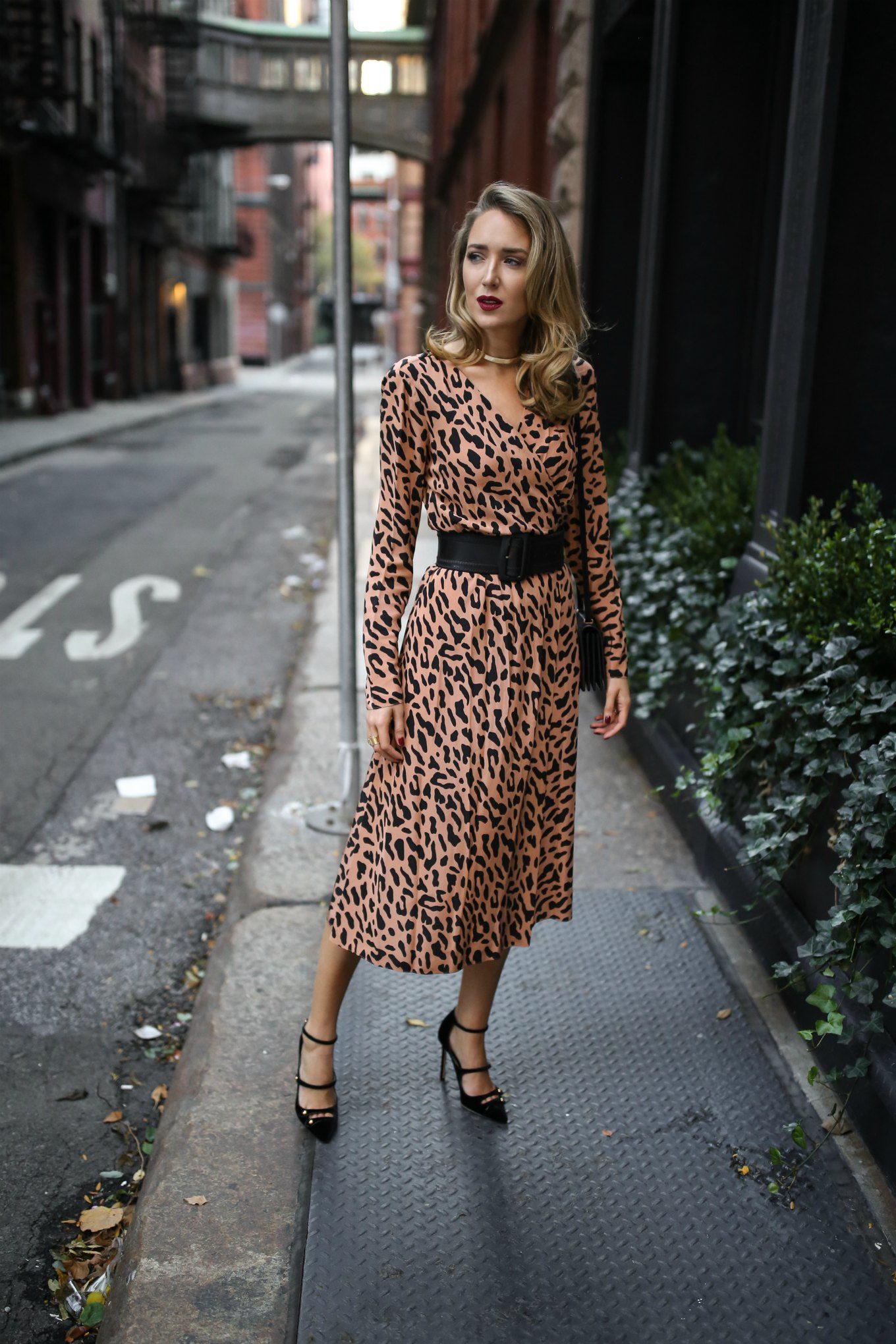Mary Orton of Memorandum wears a long sleeve leopard print DVF wrap dress, a black waist belt and black pumps