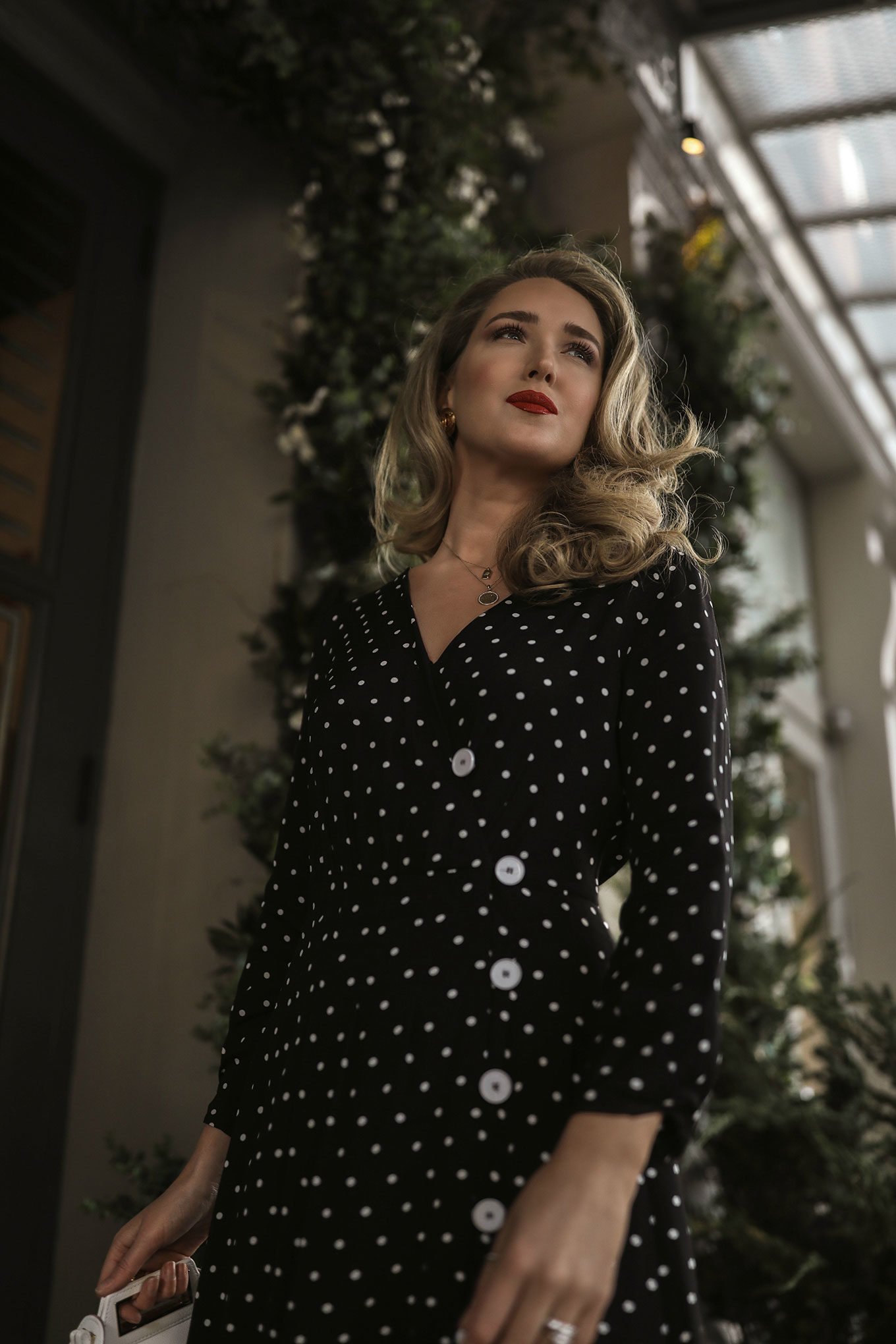 NYC style blogger wearing a polka dot dress with jewelry and red lipstick