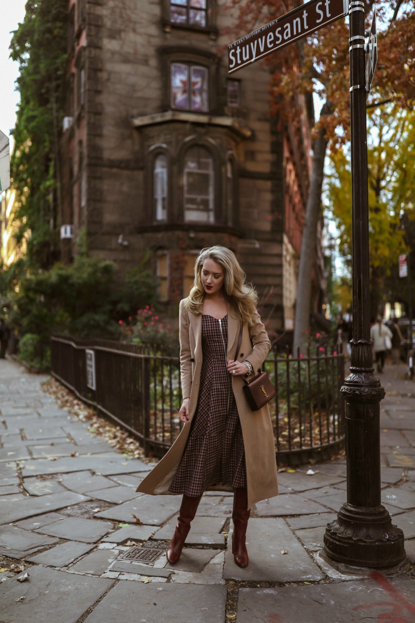 NYC style blogger on NEW York cobblestone sidewalk in dress, coat and bag