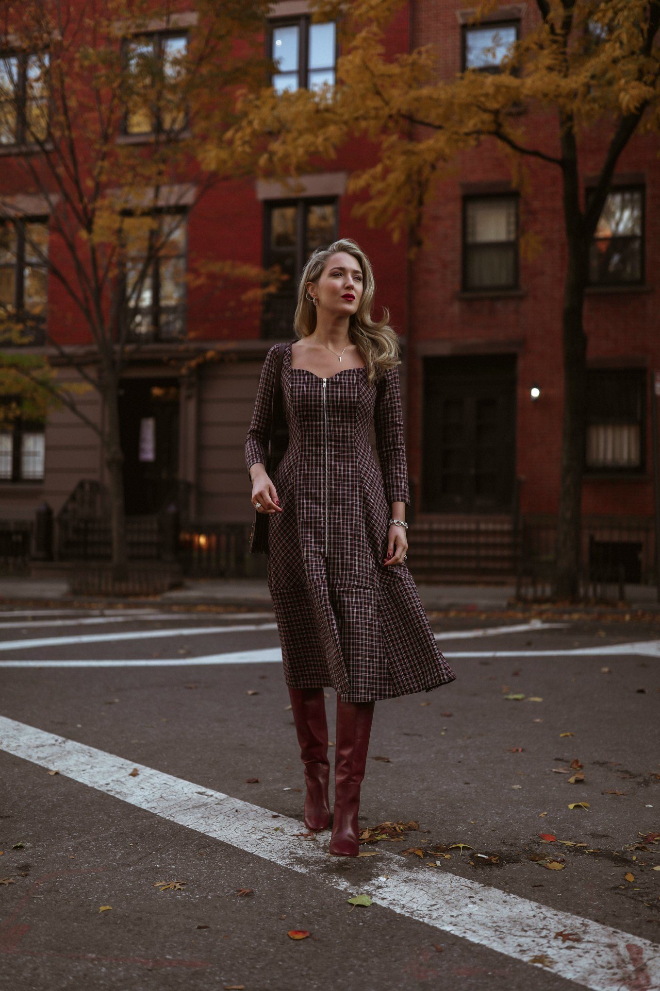 NYC style blogger wearing red plaid midi dress with boots