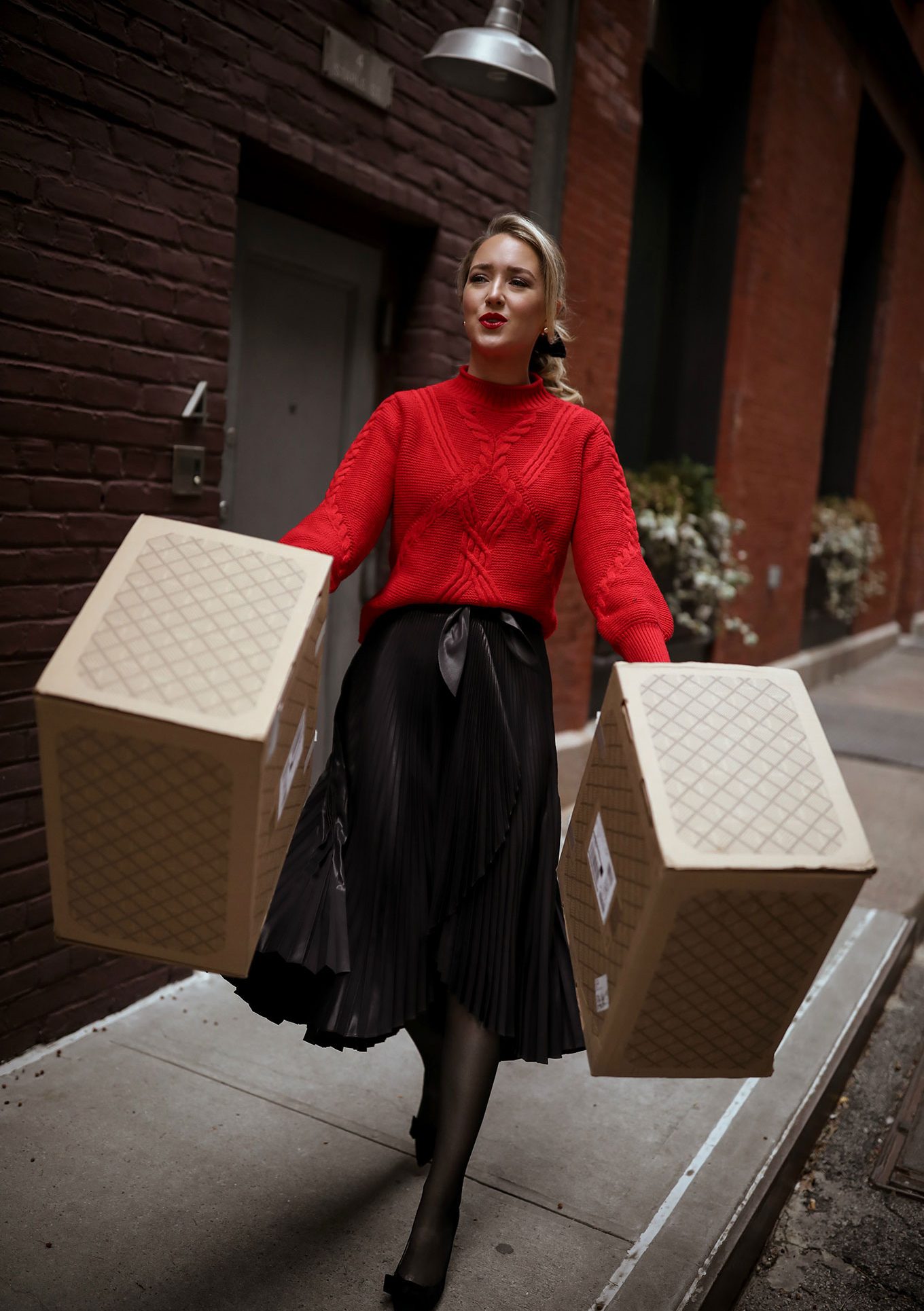 trunk-club-styling-service-holiday-shopping3-2 NYC style blogger carries two large Trunk Club trunks down city sidewalk wearing a black skirt and red sweater